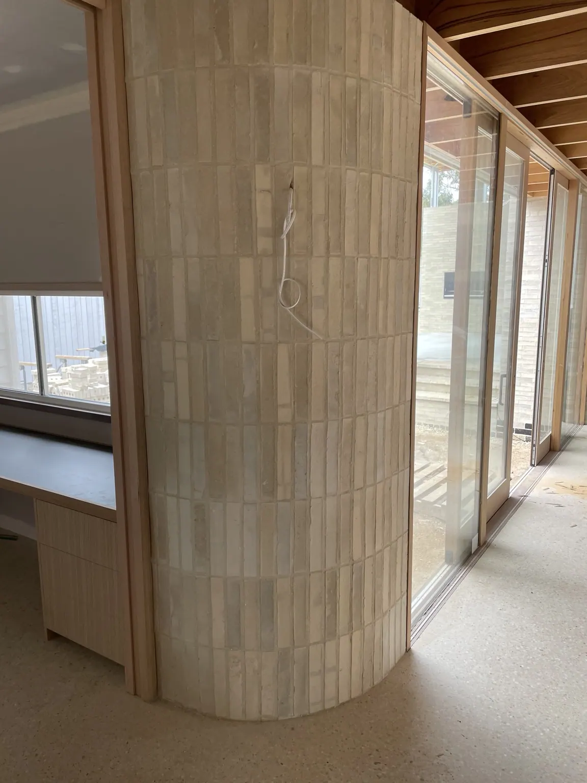 Curved interior masonry column in light brick